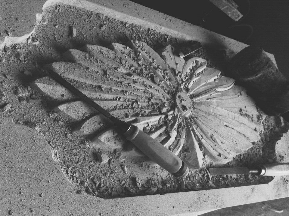 Close-up of a detailed stone sculpture, showing texture and light.